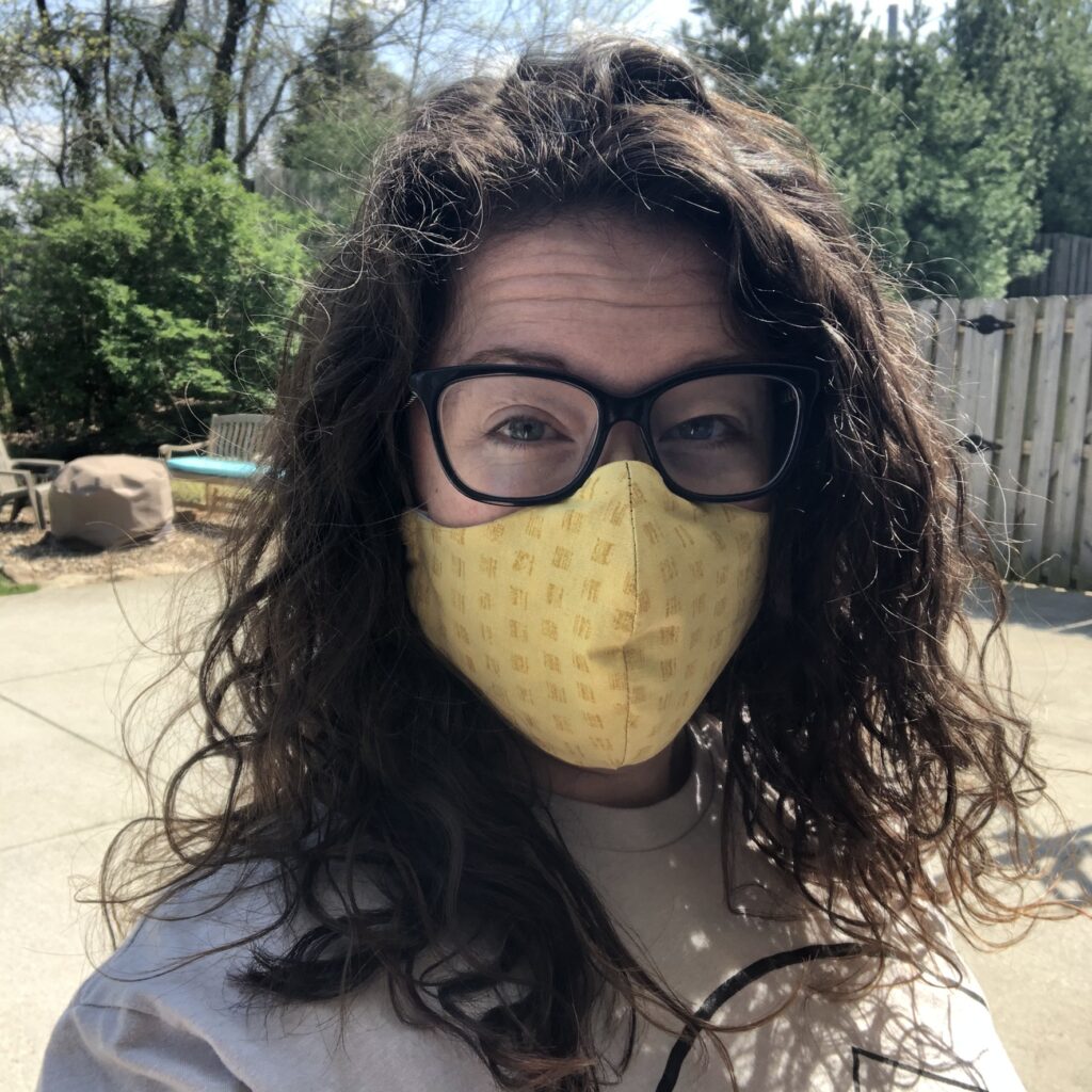 The author is shown wearing a yellow face mask.