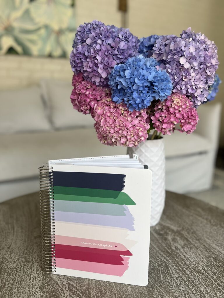 The "Embrace the Messy Bits" 2024 Makselife planner stands in front of colorful hydrangeas.
2024 Makselife planner review.